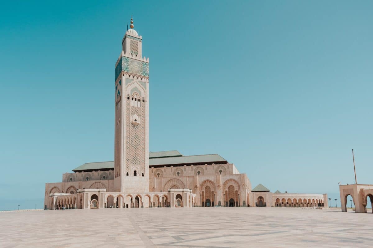 a large building with a tall tower with Hassan II Mosque in the background